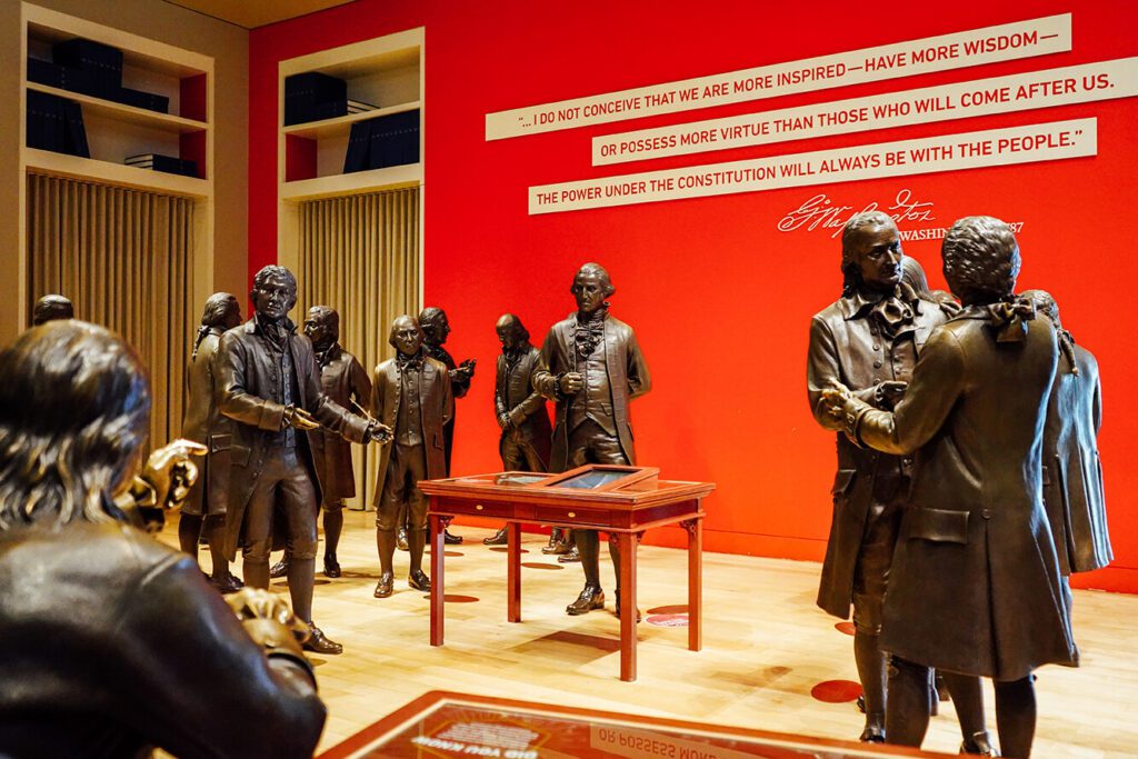 Room full of bronze statues of the United States Founding Fathers