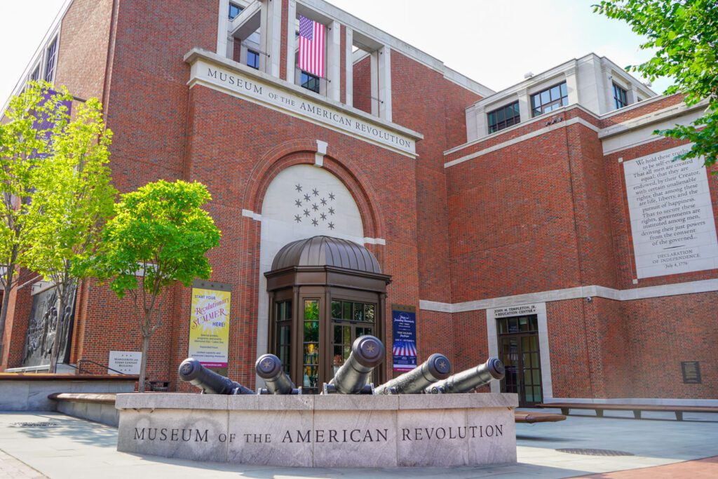 Exterior of a brick Museum with a statue of cannons.