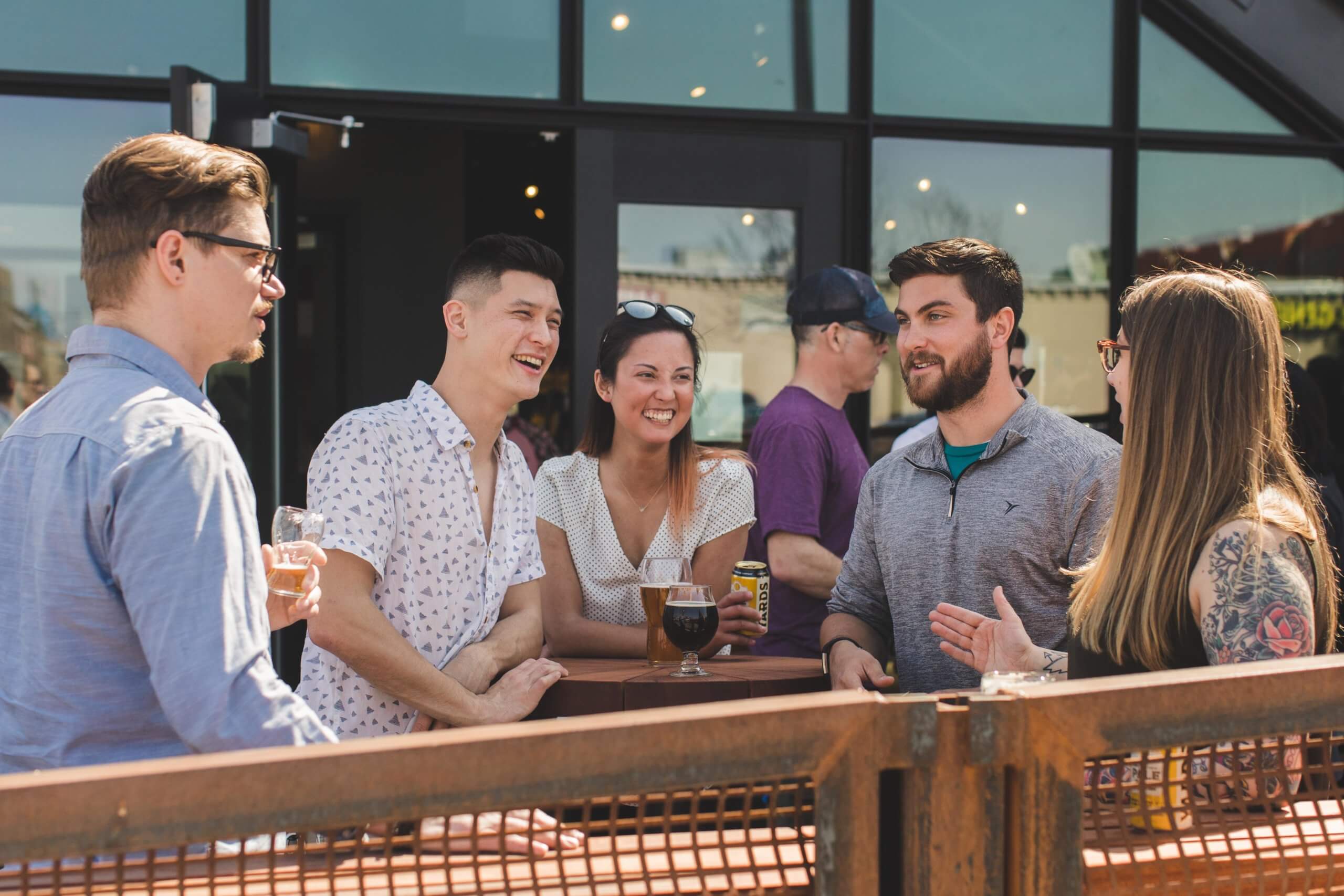 A group of people stand holding drinks outside of Yards Brewing Company's facility