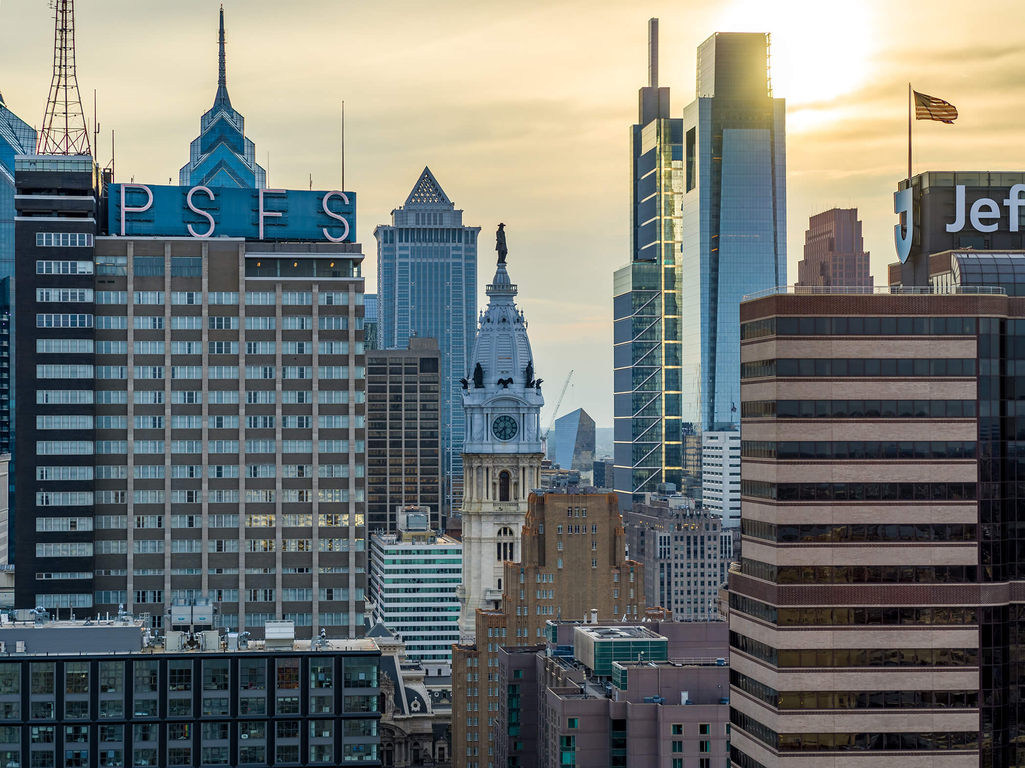 Photo of Philadelphia's city hall through the buildings at sunset.