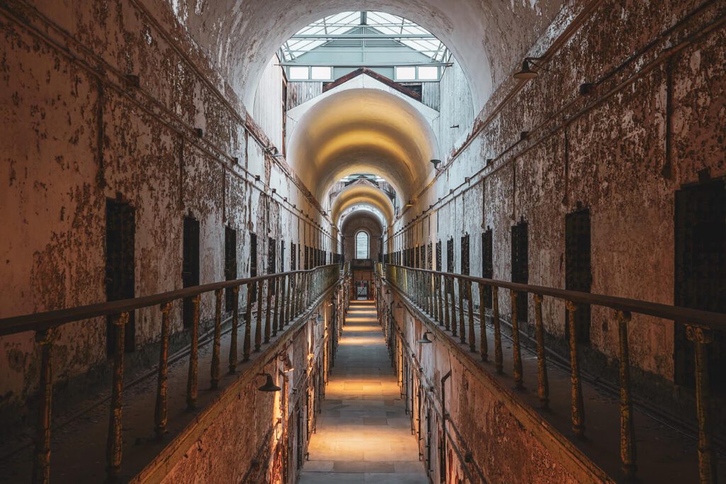 A view down a cellblock of an old, crumbling prison. 