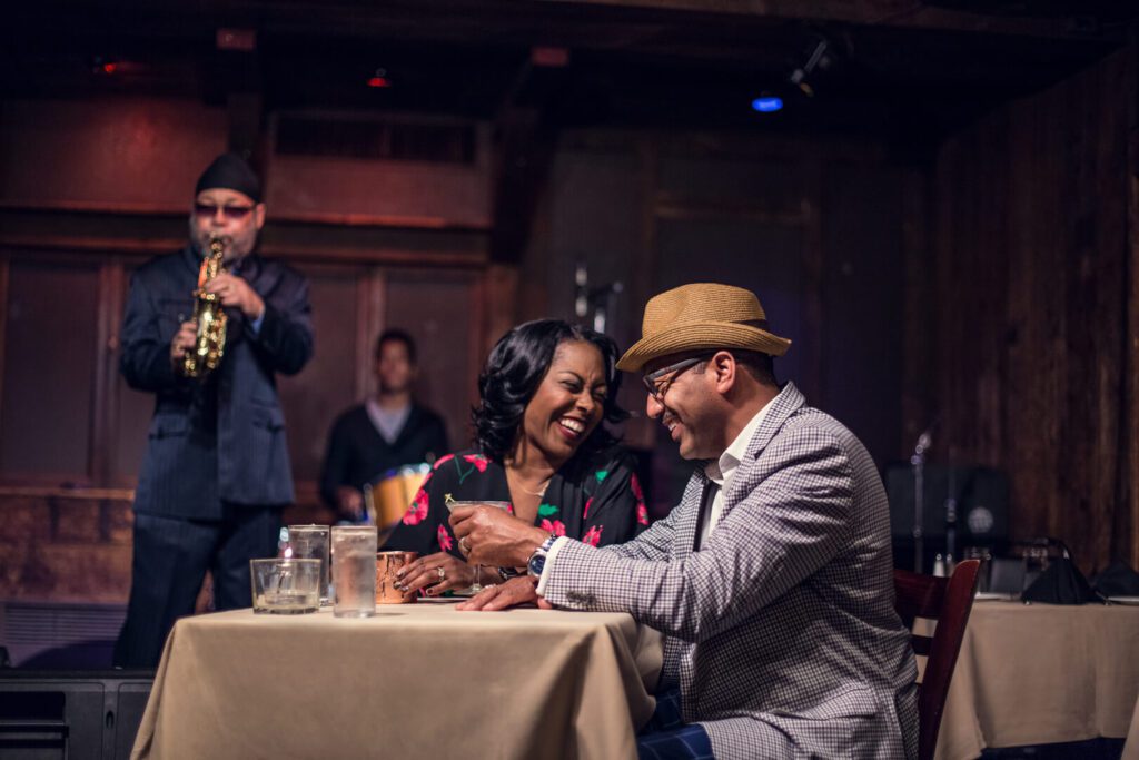 Two diners laugh with each other at a table.