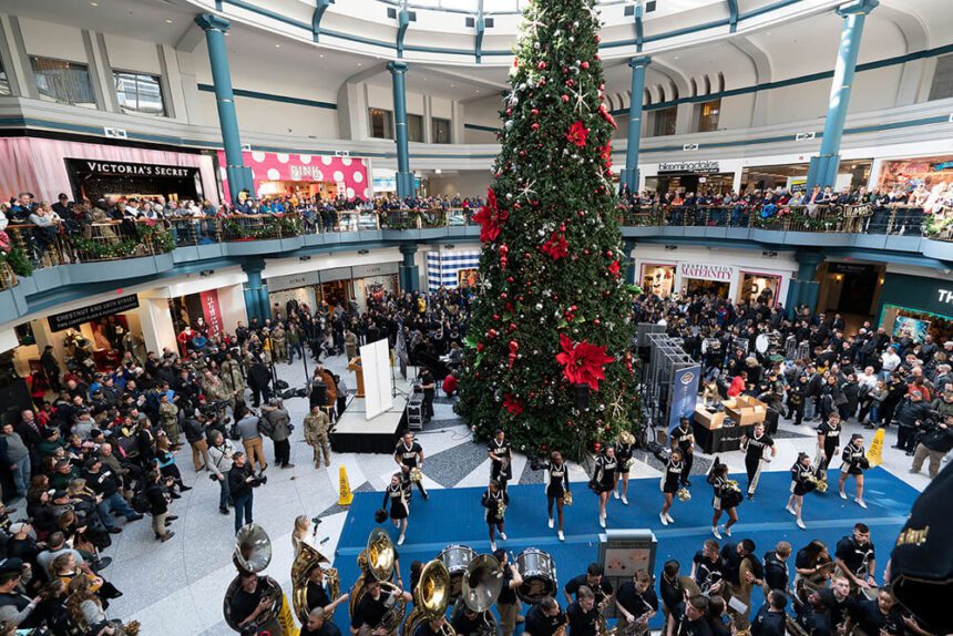 Large gathering inside a mall around a Christmas Tree.