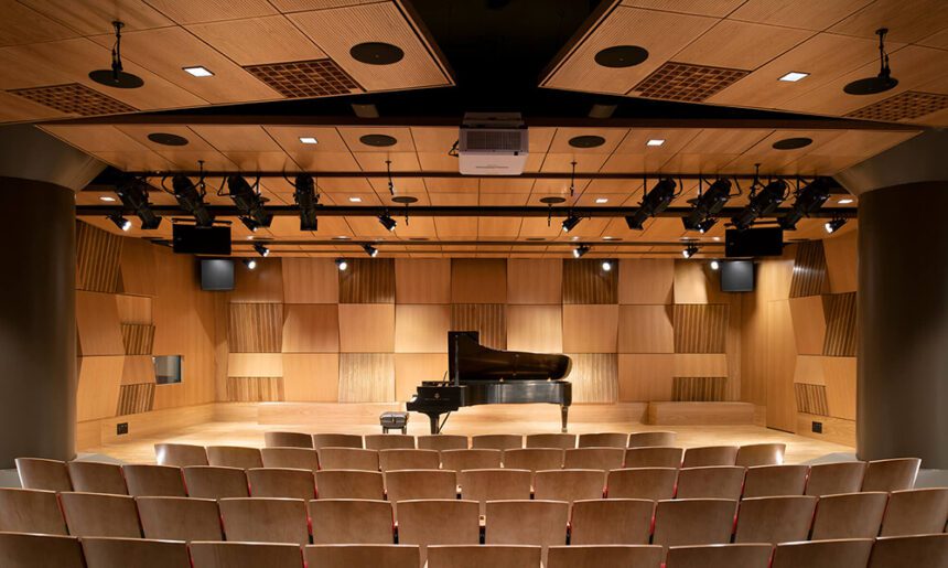 A piano on a stage inside an auditorium. 