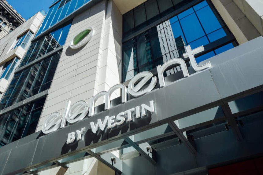 The outside of a building is shown. There is a large white and green "e" logo on the side of the building. The words underneath it read: element BY WESTIN in white lettering.