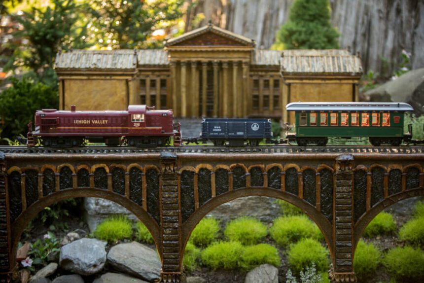 Photo of a tiny train traveling through a lush garden.