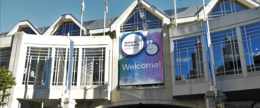 A large white building is show with a banner that reads Natural Products Expo East Welcome!