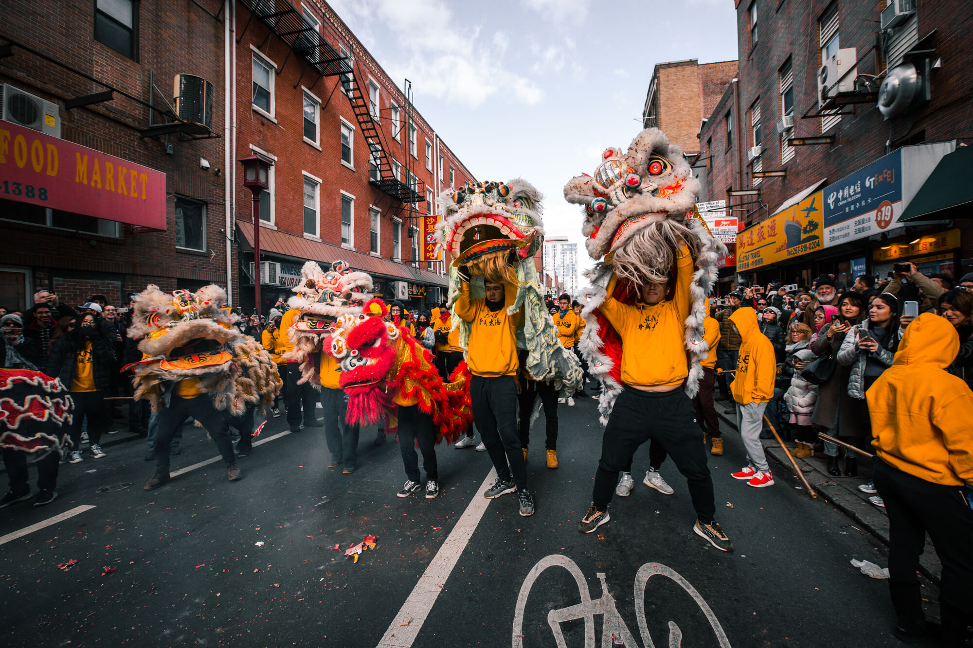 People dressed in Chinese dragon costumes parade down a city street.