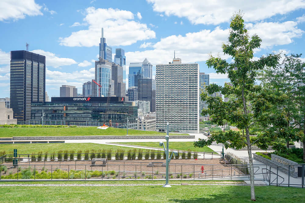 Several lawns on top of a building with the Philadelphia skyline in the background.