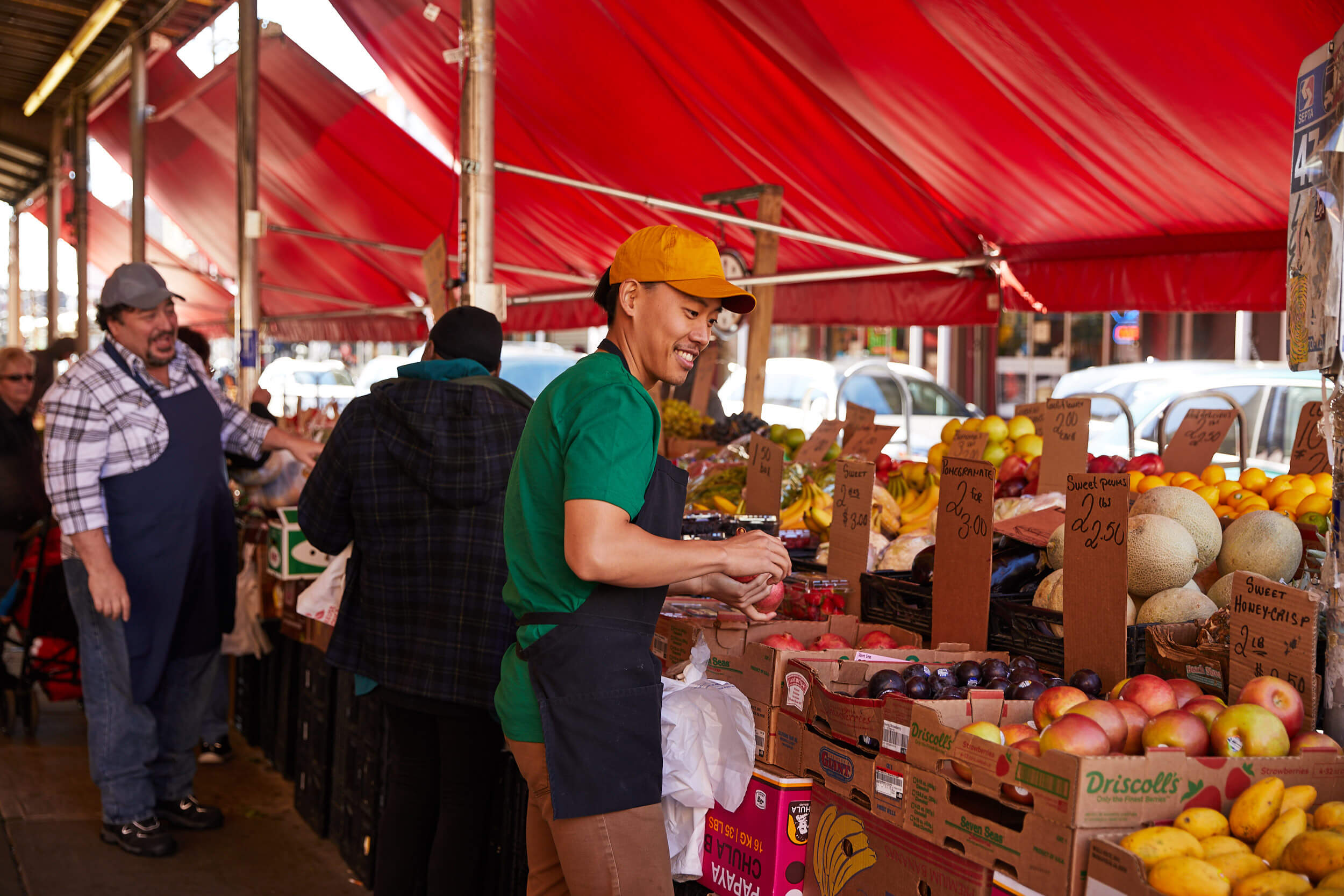 Vender in front of a fruit stand in a market