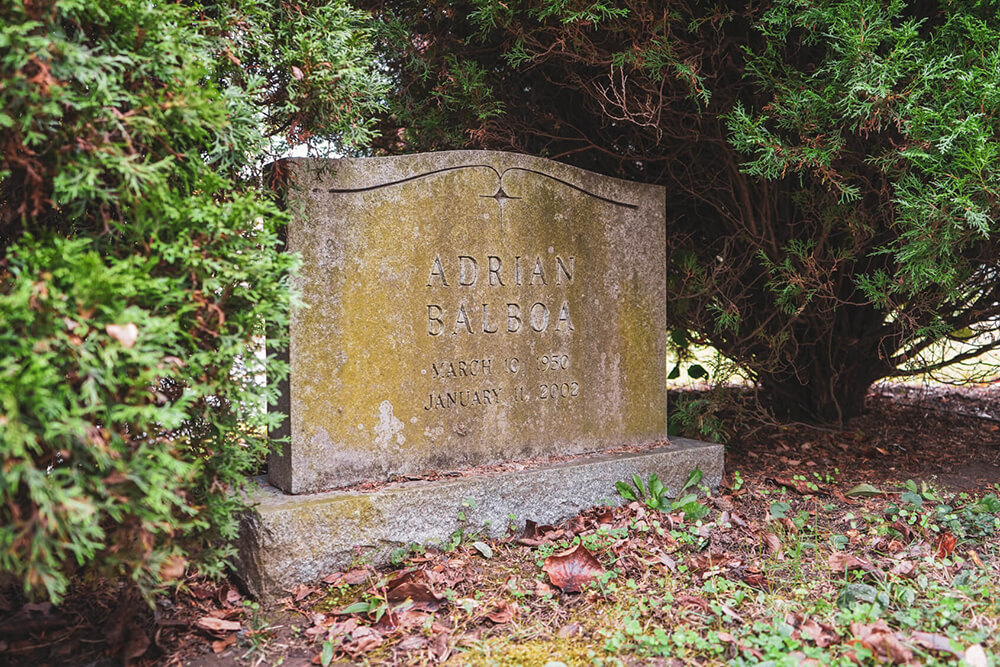 A moss covered gravestone with the name "Adrian Balboa"