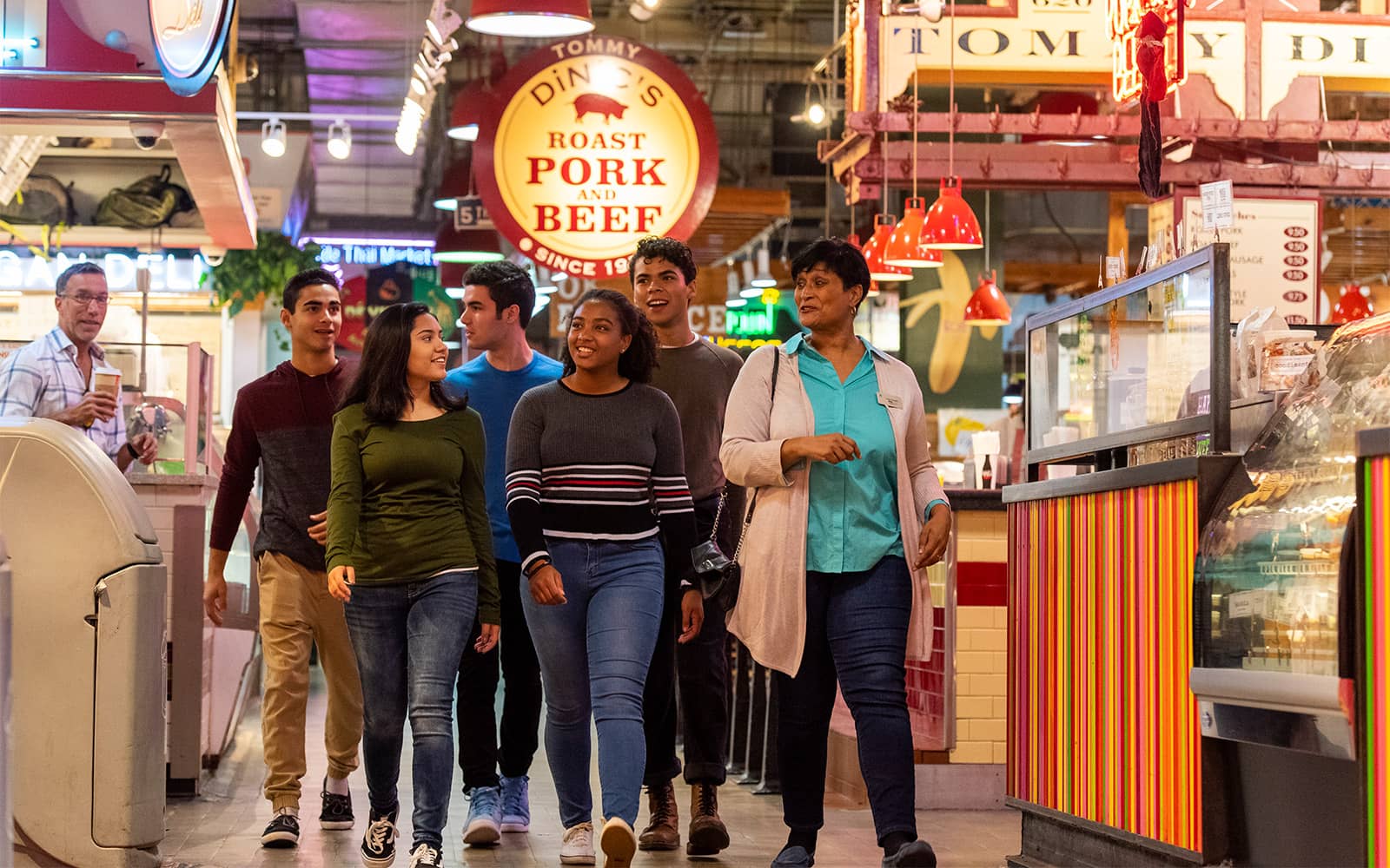 A group of people walking through the Terminal Market in Philadelphia.