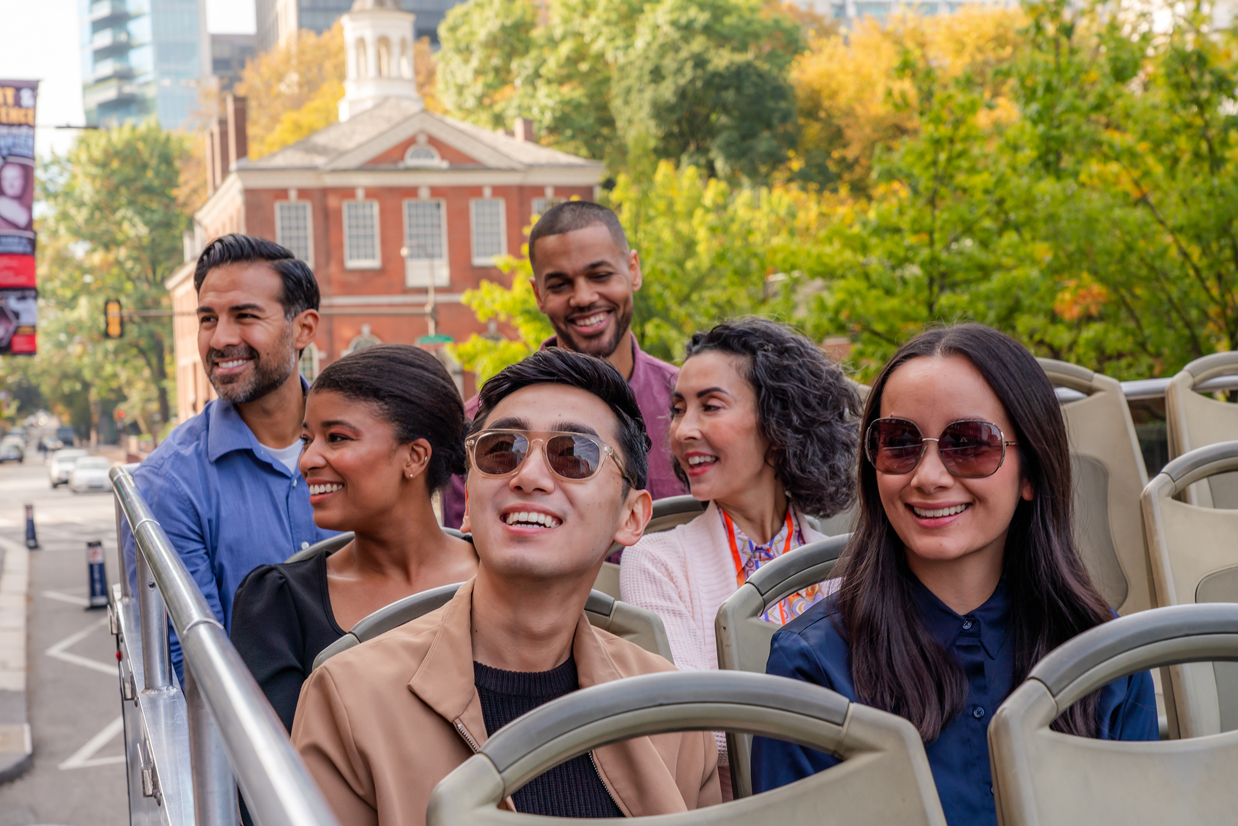 A group of people on a tour bus in front of Independence Hall.