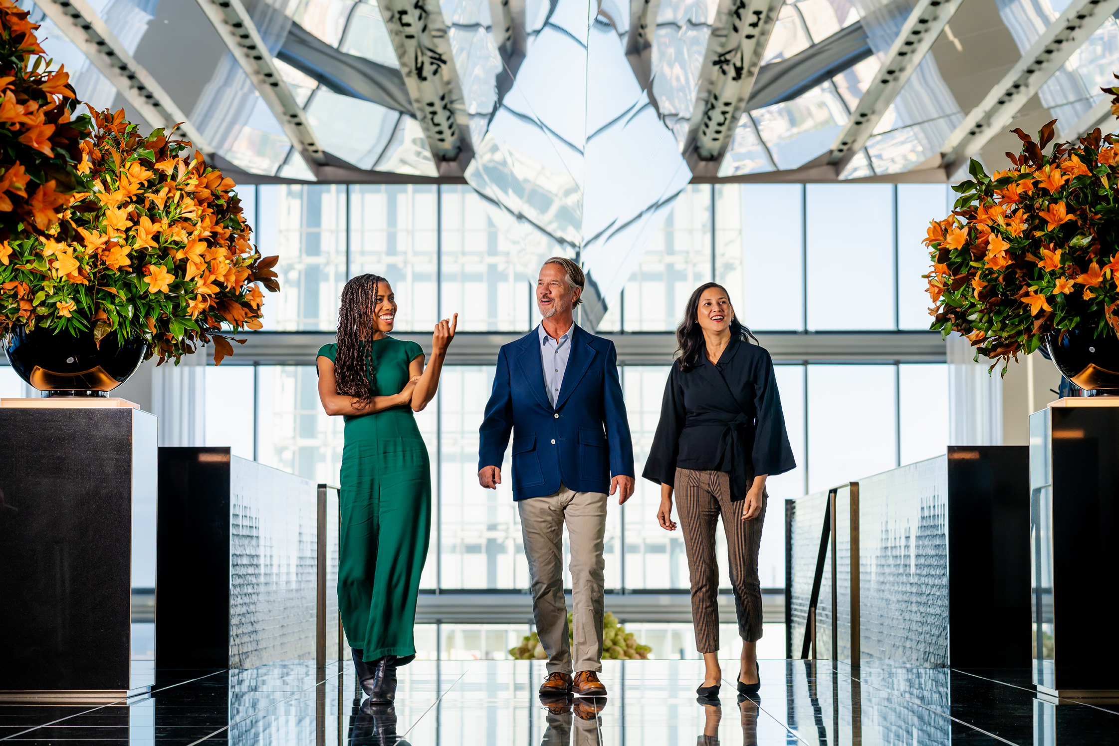 three people walk through the lobby of the Four Seasons hotel.