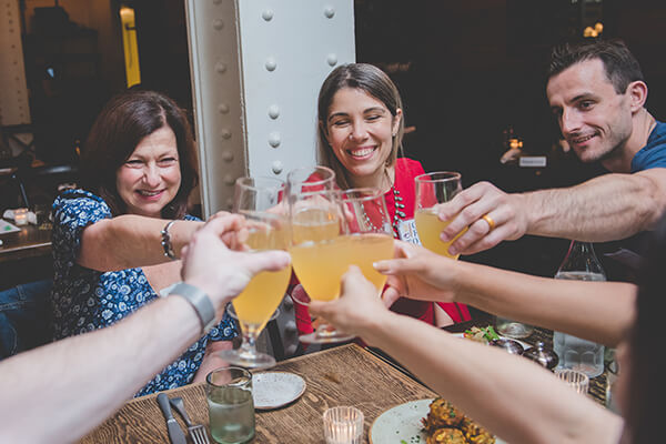 Four people cheers beers