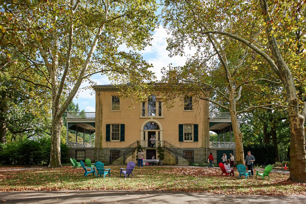 People sitting in colorful lawn chairs outside of Lemon Hill Mansion.