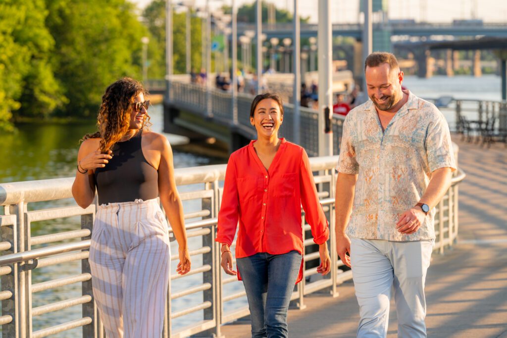 Three people walking along the Schuylkill River Trail in the sun