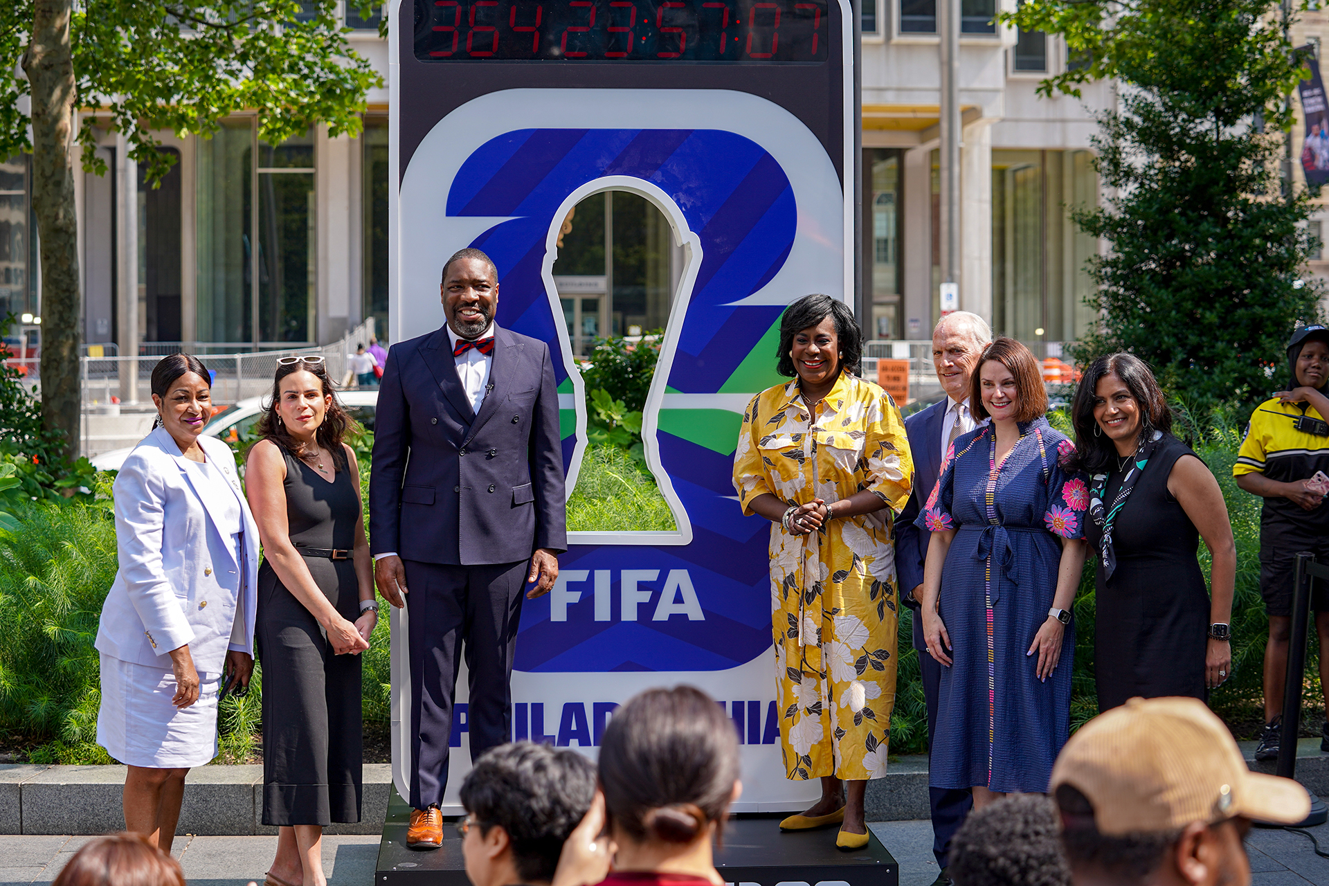 A group of Philadelphia City council members stand in front of the FIFA Clock at City Hall.