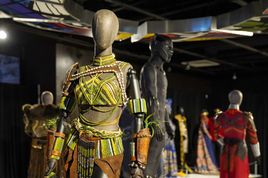 A mannequin in a museum is adorned with costuming from the film Black Panther. 
