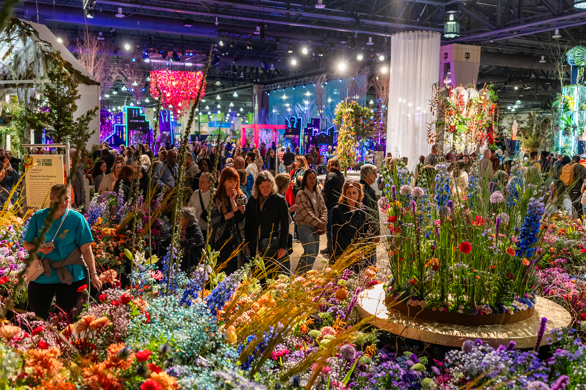 A group of people look over an elaborate display of flowers at the Philadelphia Flower Show.