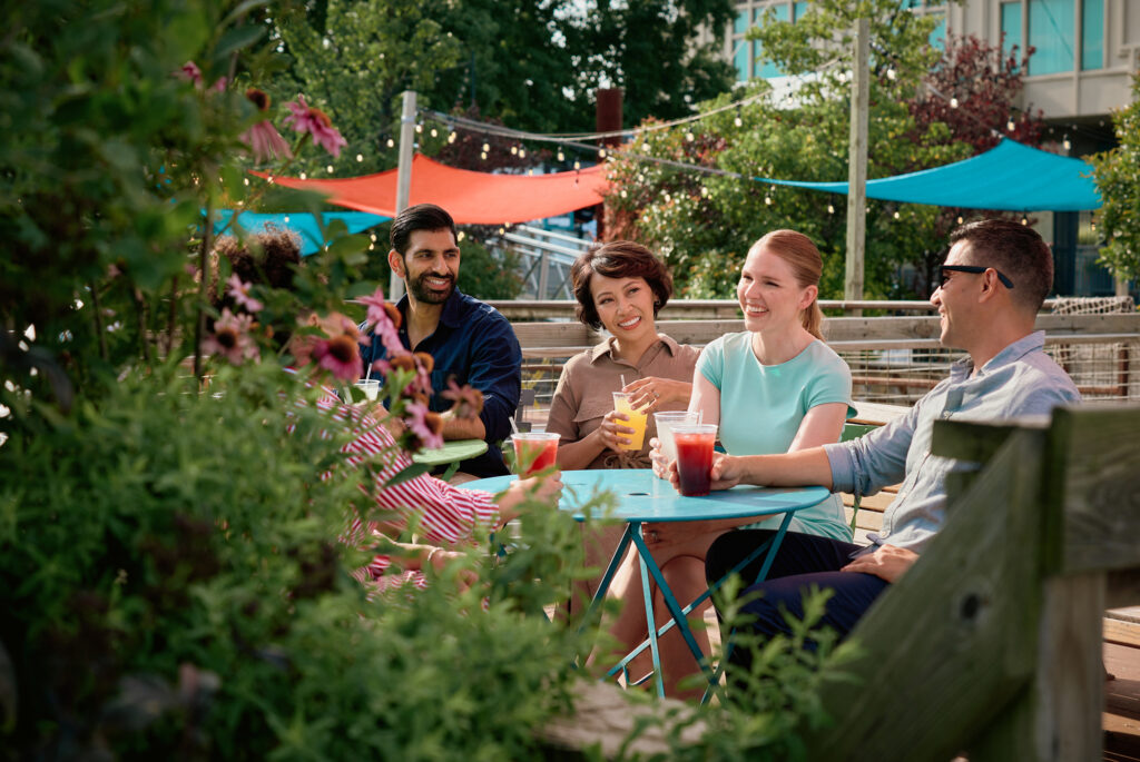 A group of people sit together outside, laughing.
