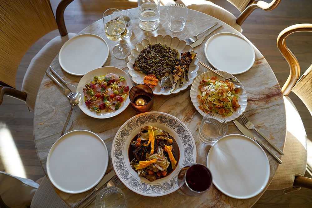 A table in a restaurant filled with entrees and plates