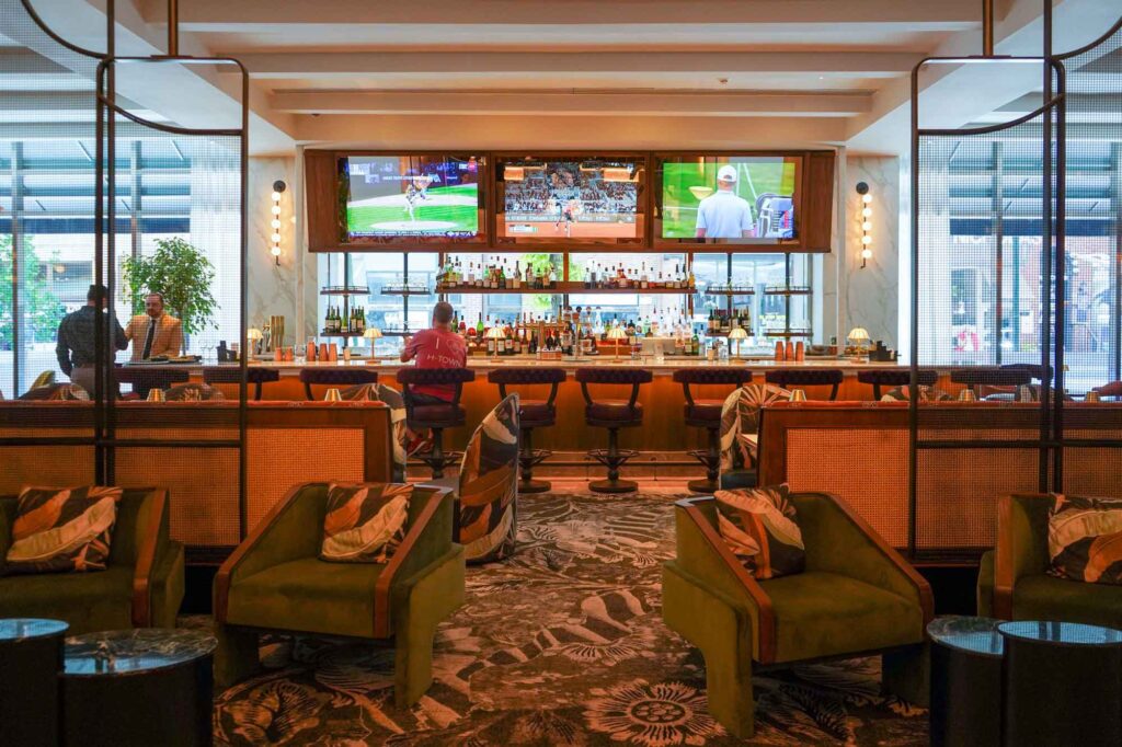 A hotel bar sits in the background of a newly decorated lobby.