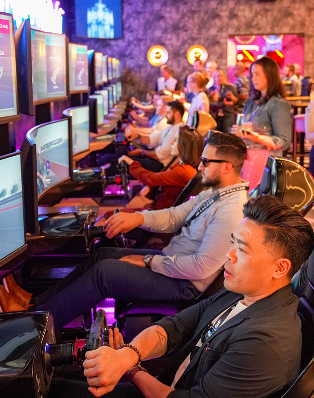 A row of people race at the F1 Arcade.