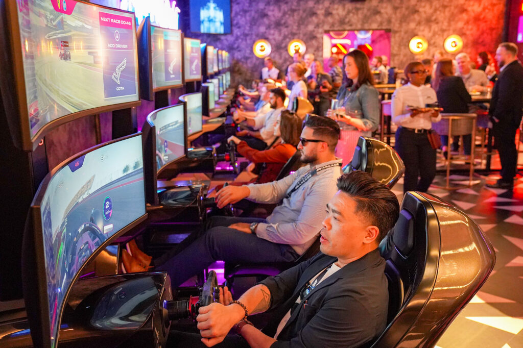 A row of people race at the F1 Arcade.