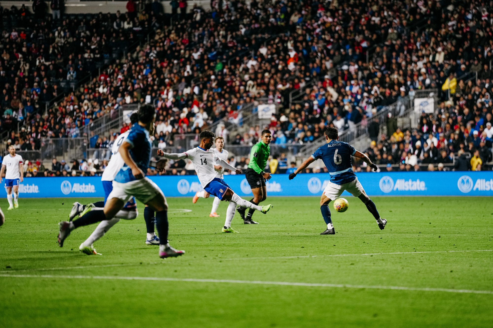A group of soccer players fight for the ball during a game.
