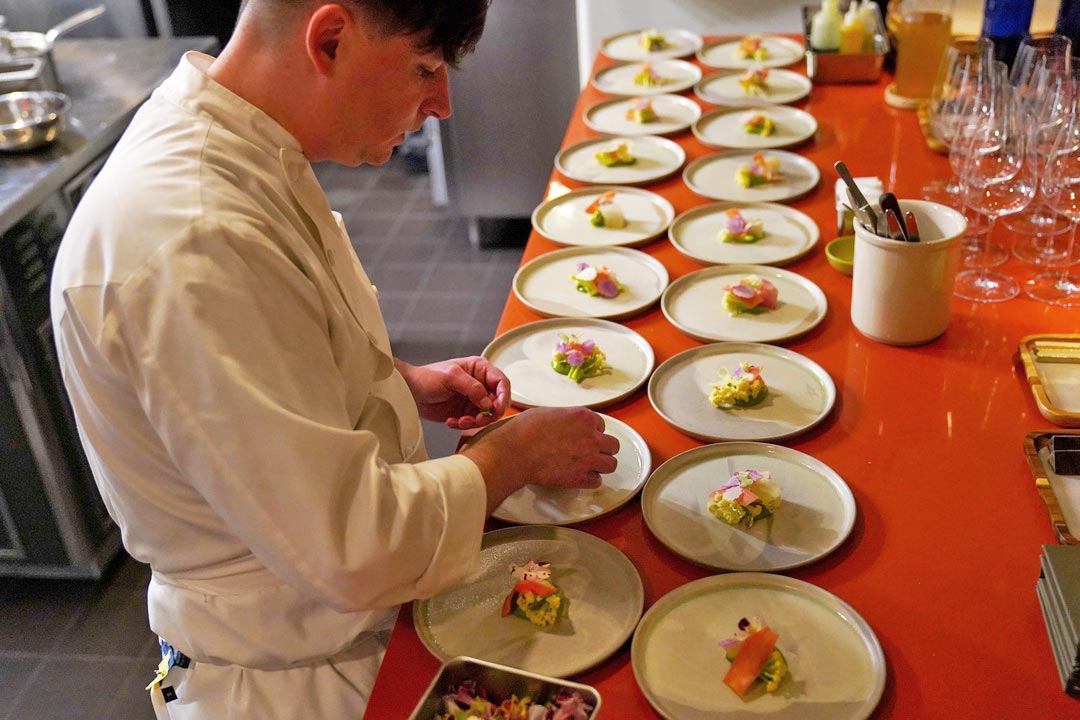 A chef plates food in a restaurant.