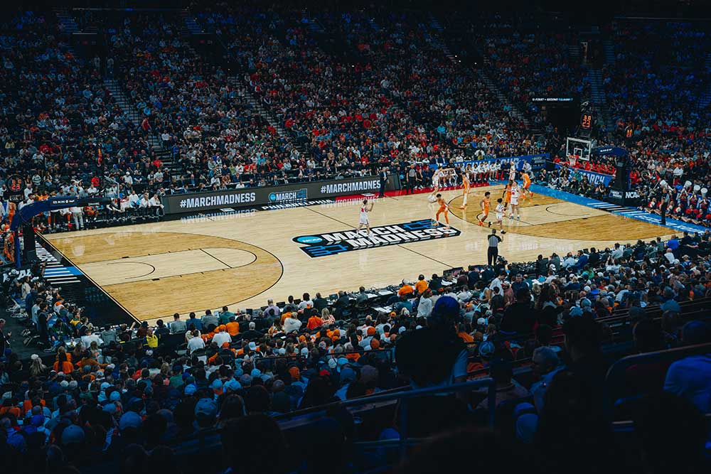 the xfinity mobile arena basketball court is surrounded by fans for March Madness