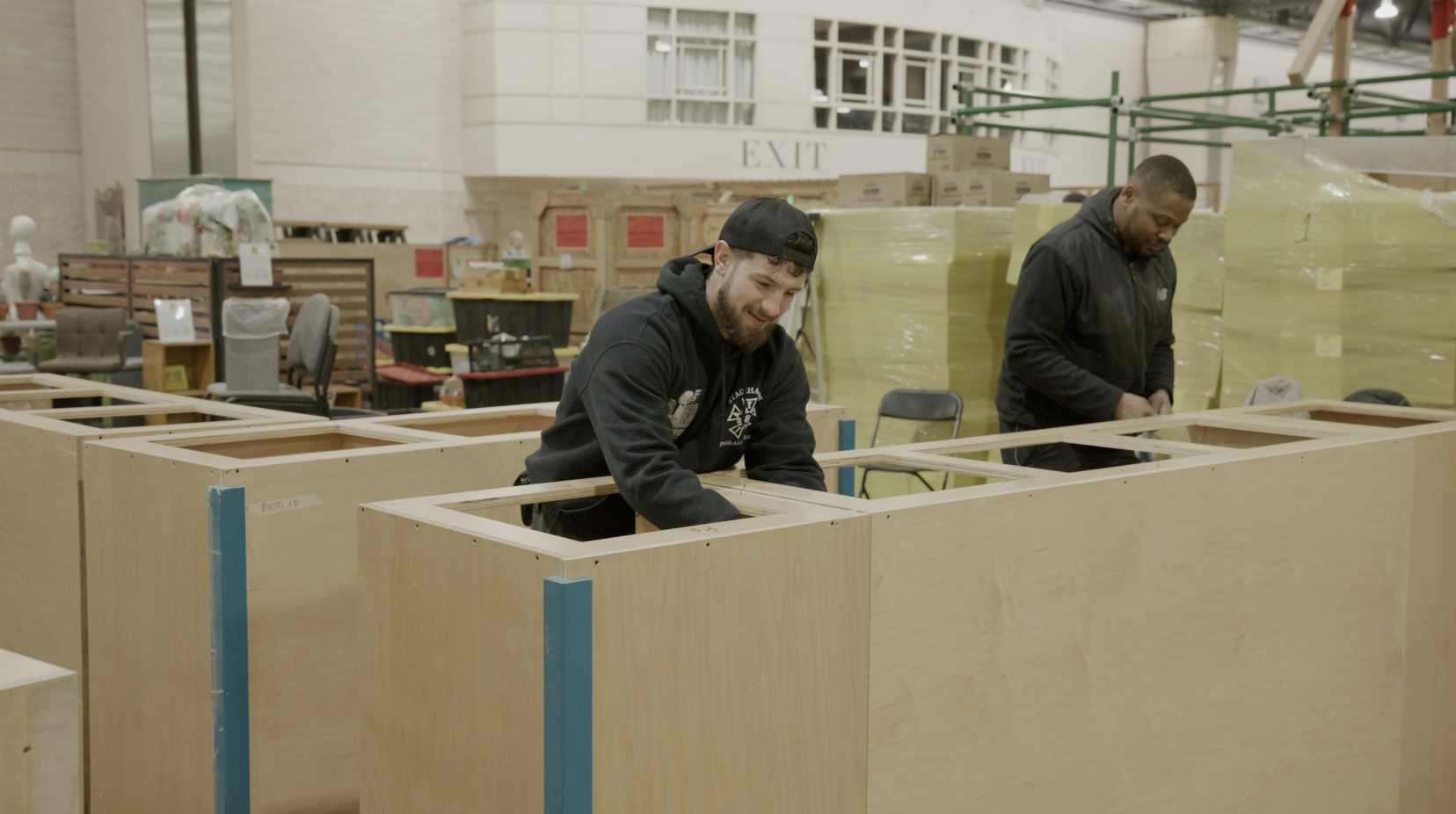 Two men construct a booth on the PA Convention Center showroom floor