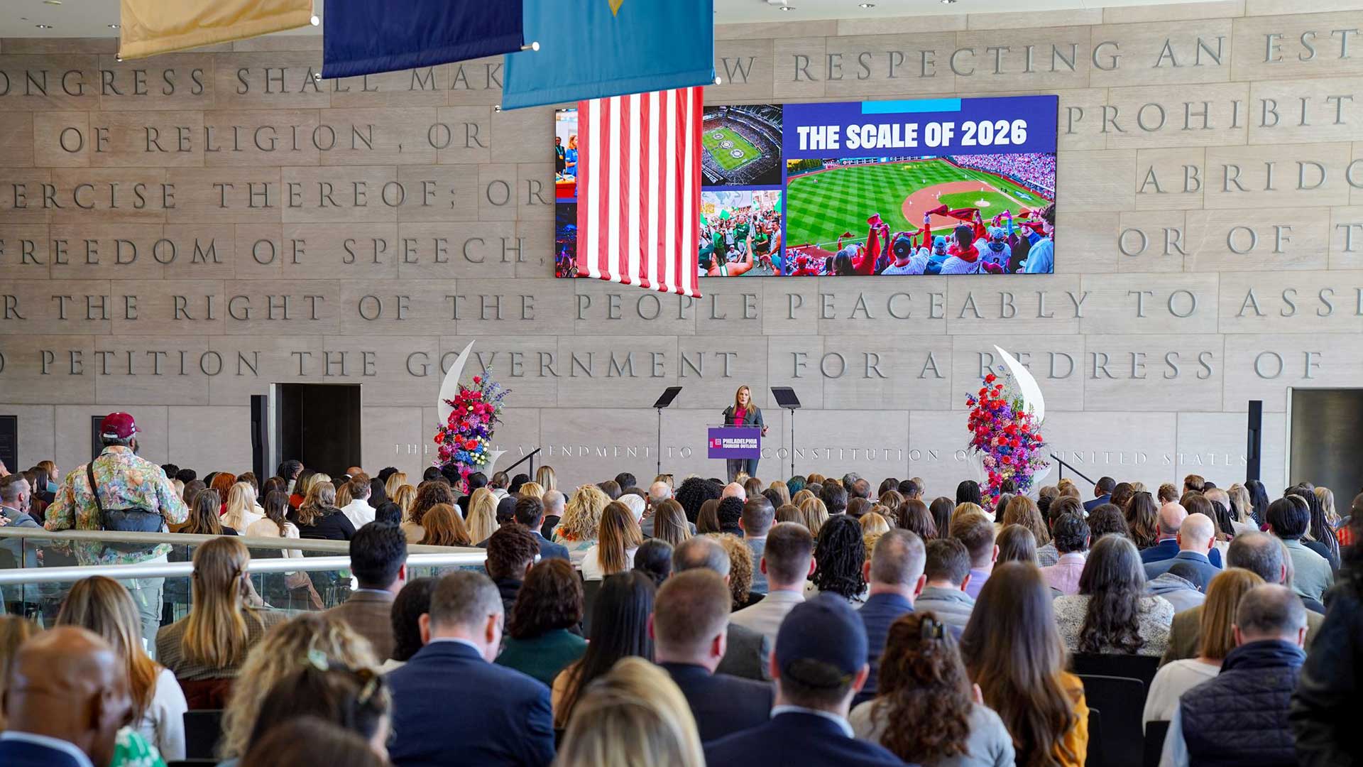 An individual speaks at a podium in front of a large crowd at the National Constitution Center