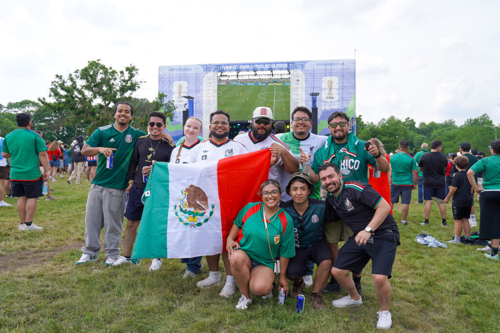 A group of World Cup fans pose for a photo with their team flag.