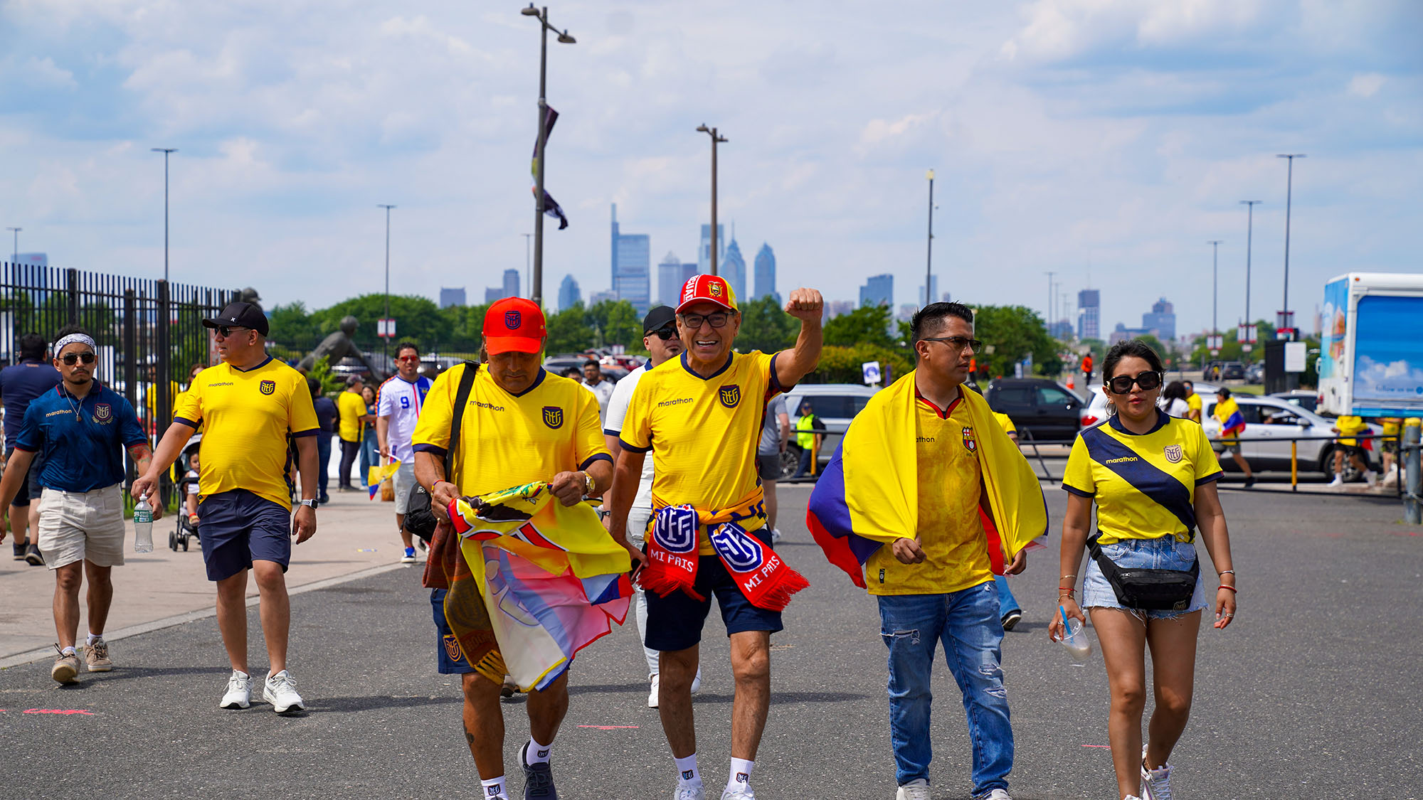 A World Cup fan holds out his fist in excitment, the city skyline in the background.