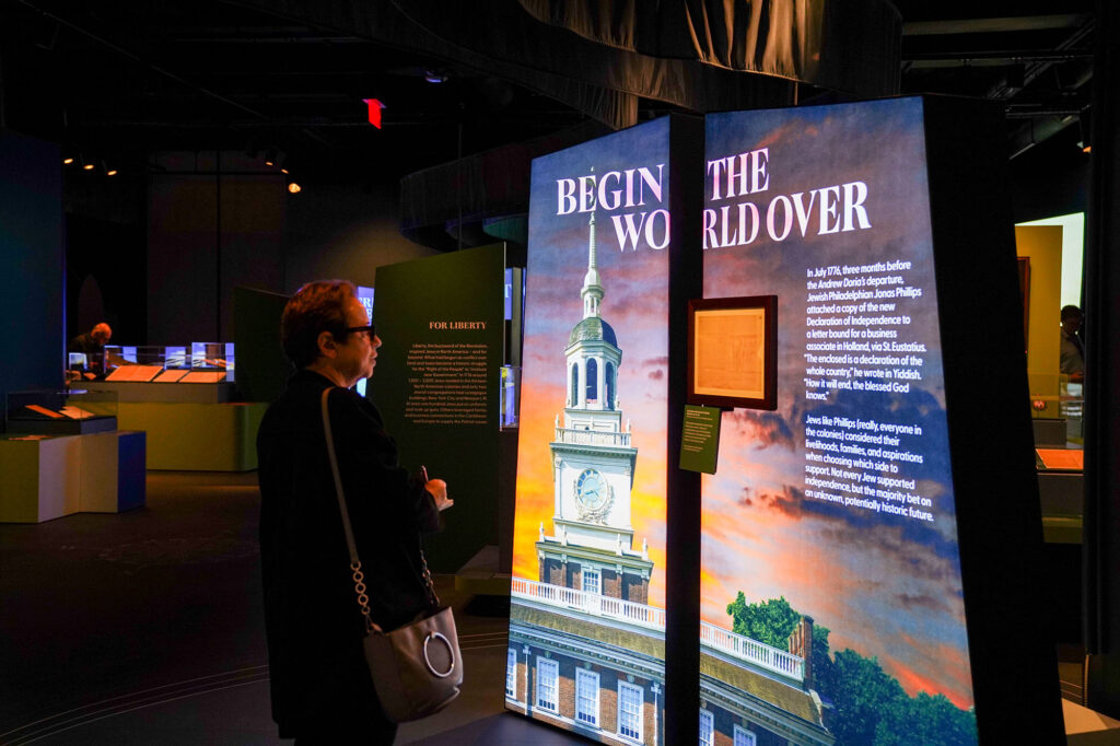 A person looks at a glowing sign in the First Salute gallery.