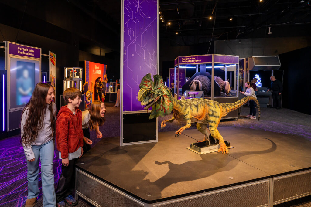 Some kids laugh a scream looking at a replica of a dinosaur in the Franklin Institute.